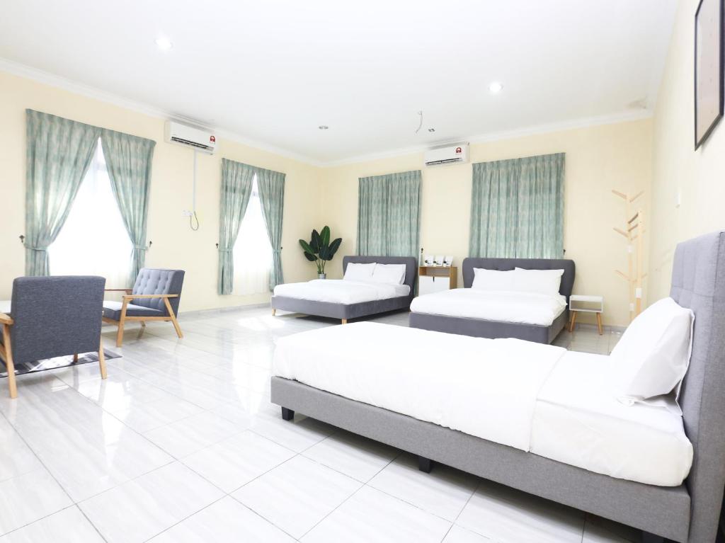 una camera con due letti e un divano e sedie di Aloha Chalet a Kampung Raja