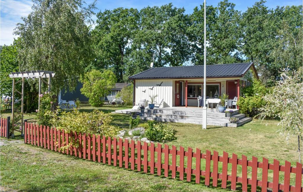 a house with a red fence in front of a yard at Beautiful Home In Frjestaden With Wifi in Färjestaden