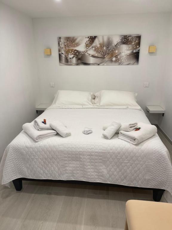 een slaapkamer met een bed met handdoeken erop bij Grand studio neuf à 50 m du port in Saint-Tropez