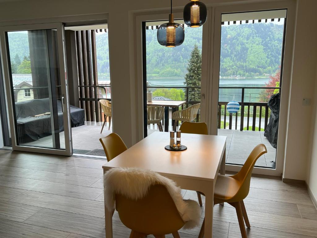 ein Esszimmer mit einem Tisch und Stühlen sowie einem Balkon in der Unterkunft Ferienwohnung mit Seeblick - Ossiacher See Gerlitzen in Sattendorf