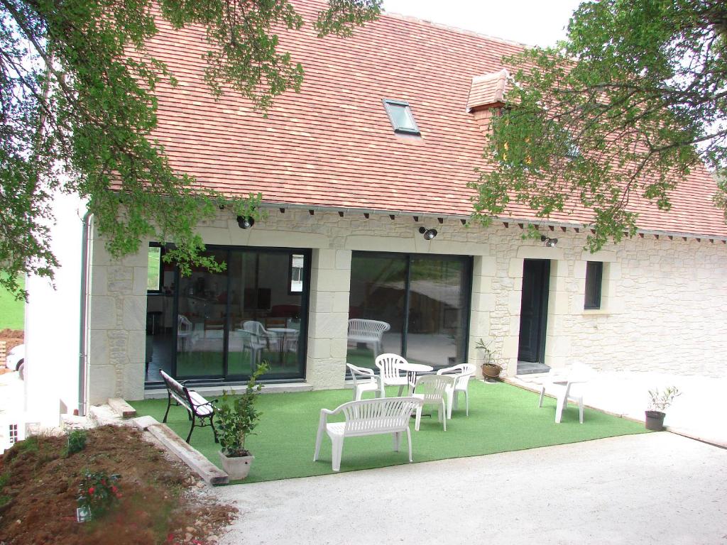 a patio with chairs and tables on a lawn at GITE DE 6 A 14 PERSONNES Chez Léontine in Lacave