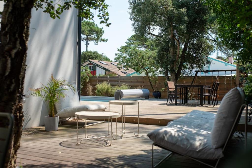patio z kanapą, stołem i stołem w obiekcie Superbe villa 5* avec piscine chauffée w mieście Labenne