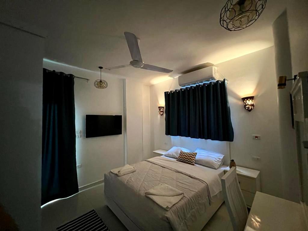a bedroom with a bed and a ceiling fan at Moon House of Luxor in Luxor