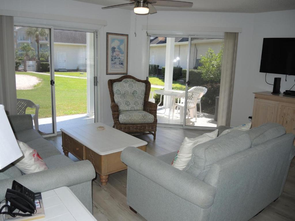 Sala de estar con 2 sofás y mesa en Golf Resort Villa 1503 Steps to Pool, en Calabash