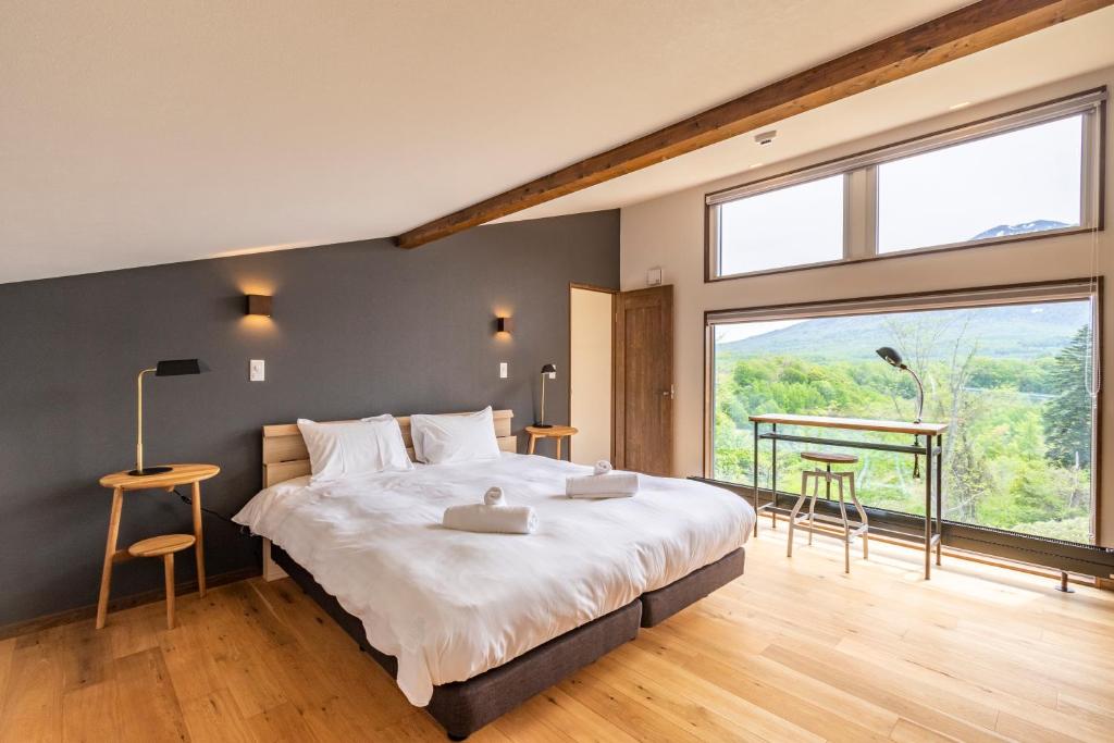 a bedroom with a large bed and a large window at SANGA HOUSE in Kutchan