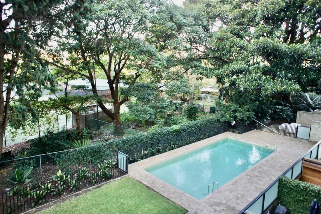 an overhead view of a swimming pool in a garden at Lovely refurbished 1 bed near marina + parking in Sydney