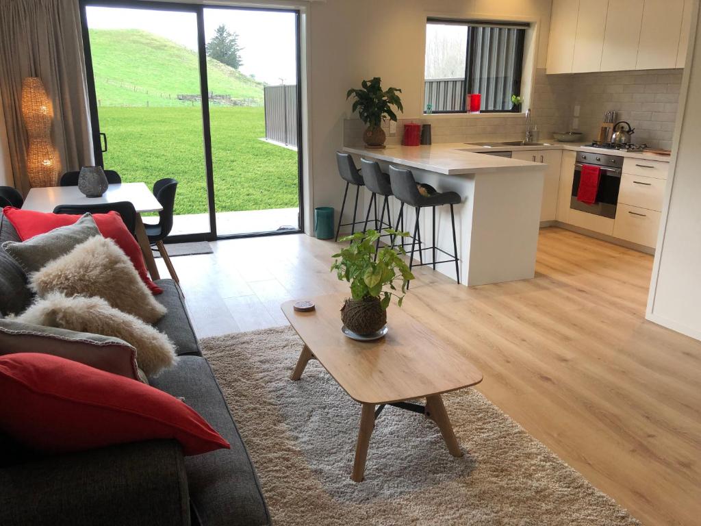 a living room with a couch and a table at Brightside Cosy Farmstay in Papamoa