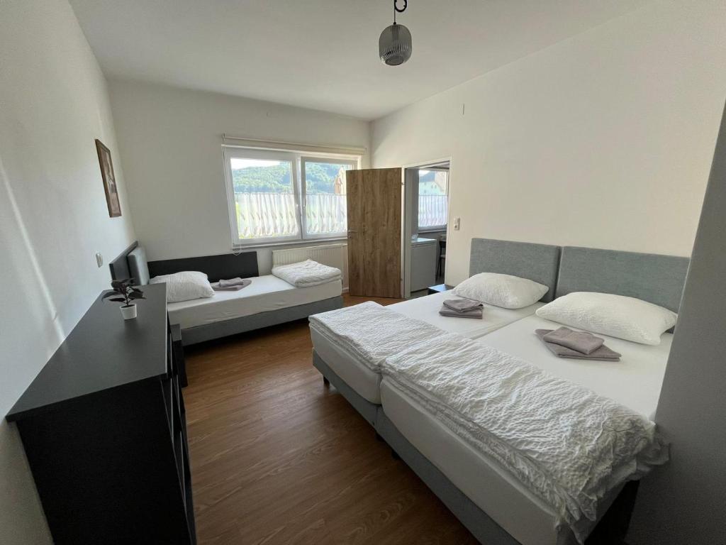 um quarto com duas camas e um sofá em Danner Familien-Ferienwohnungen Schörfling am Attersee em Schörfling