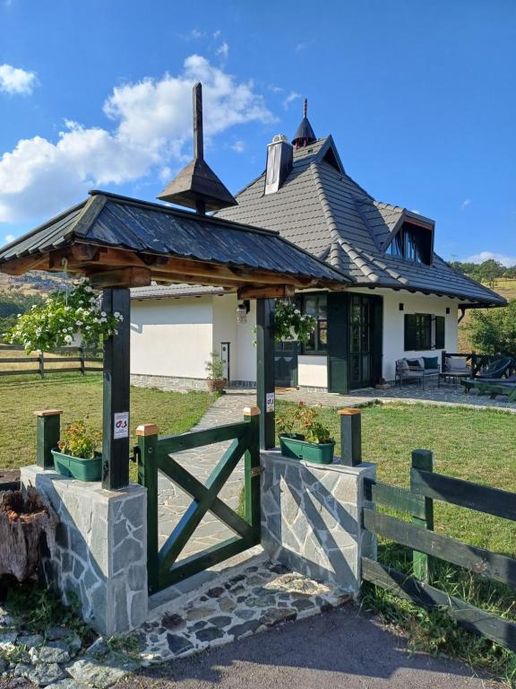 un edificio con una puerta y una valla en Casa Mila Zlatibor en Zlatibor