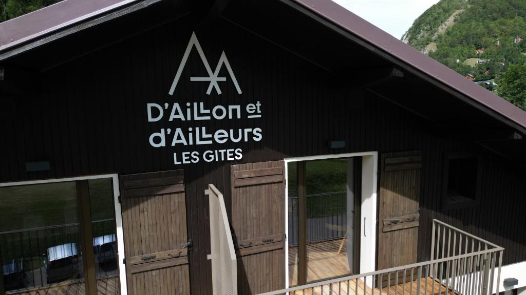un bâtiment noir avec un panneau sur son côté dans l'établissement Les Gîtes d'Aillon et d'Ailleurs, à Aillon-le-Jeune