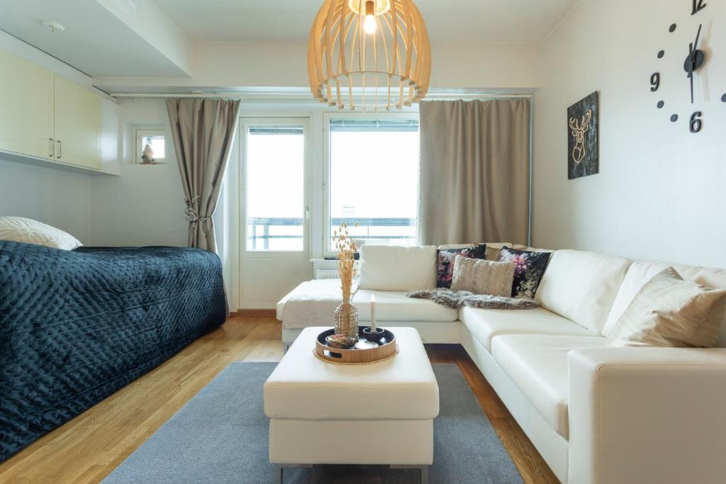 Una sala de estar con un sofá blanco y una mesa. en Vasko luxurious suites, Hiisi, en Rovaniemi