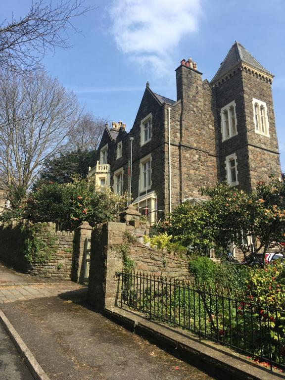 an old brick building with a fence in front of it at Westbrook-Homestay in Swansea