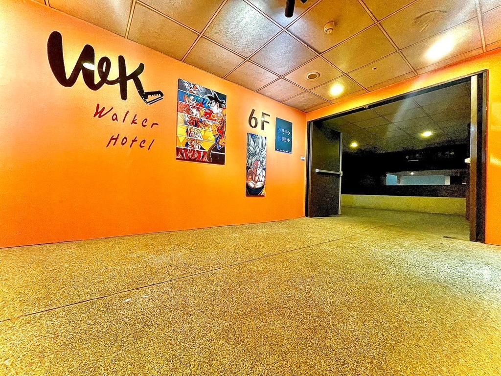 uma sala vazia com uma parede laranja com as palavras "wolf wake detroit" em Walker Hotel - Zhengyi 2 em Taipei