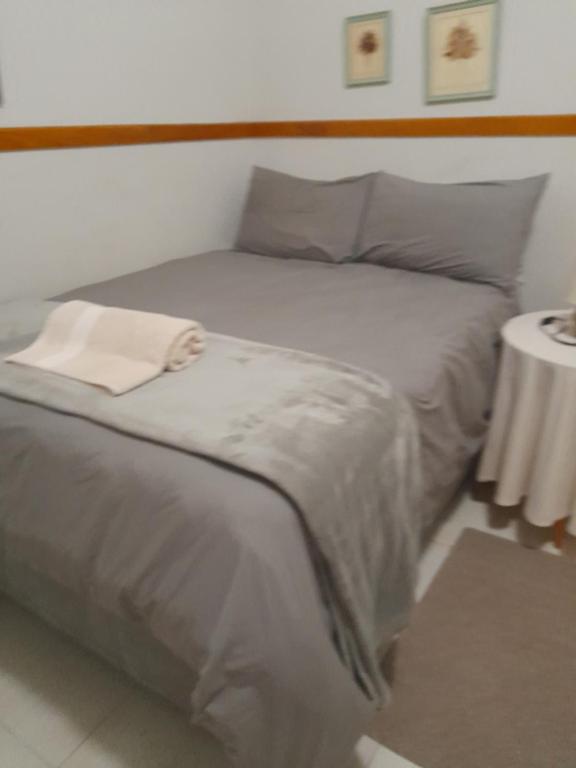 a bedroom with a bed with a white towel on it at Koppie Allen guest house in Pongola