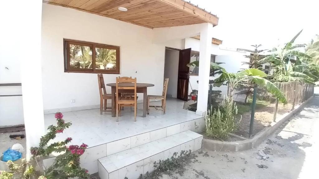 ein Haus mit einem Tisch und Stühlen auf einer Veranda in der Unterkunft TULEAR APPARTEMENTS CHAMBRES VILLAs in Toliara