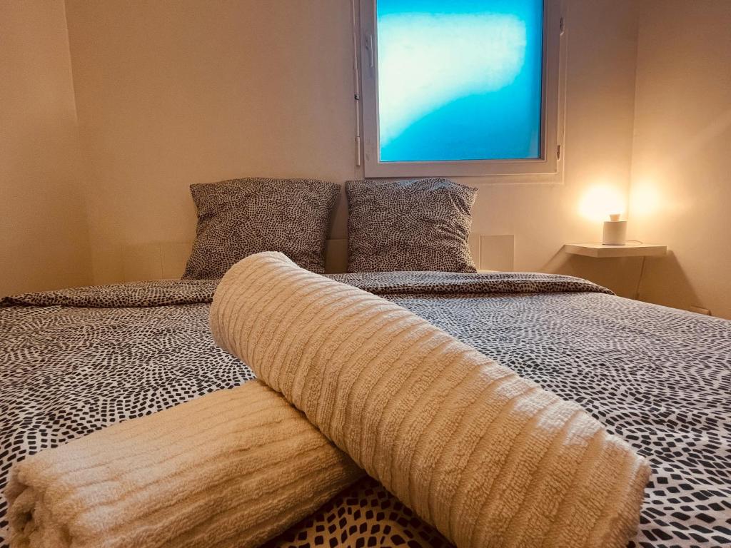 een slaapkamer met een bed met een deken erop bij L'escale Grignoise in Grigny