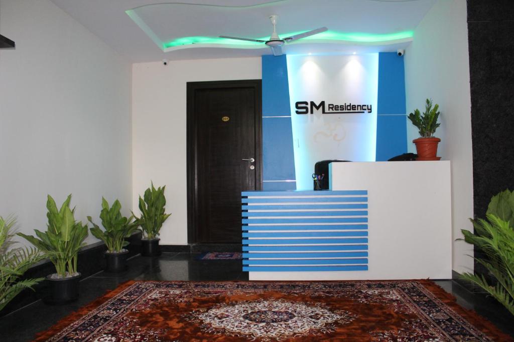 a lobby with a samsung sign on the wall and plants at S M RESIDENCY HOTEL in Bangalore