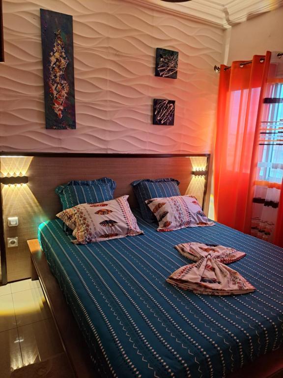a bedroom with a bed with two pillows on it at Chez Roland in Kribi
