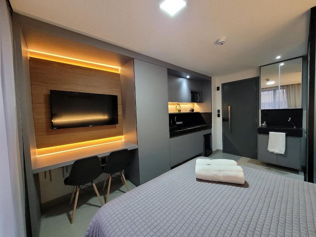 a hotel room with a bed and a flat screen tv at Excelente Flat no Bessa a 50m da praia in Tambaú
