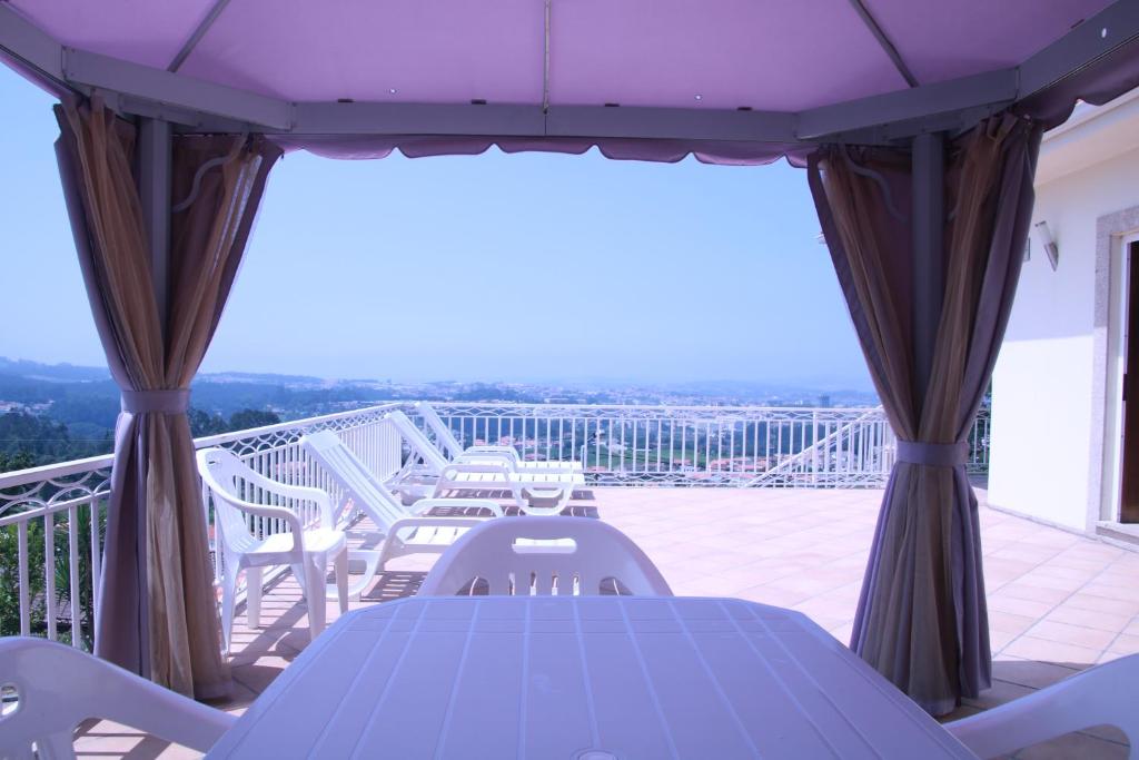 d'un balcon avec une table bleue et des chaises sur une terrasse. dans l'établissement cerca do casal, à Santo Tirso