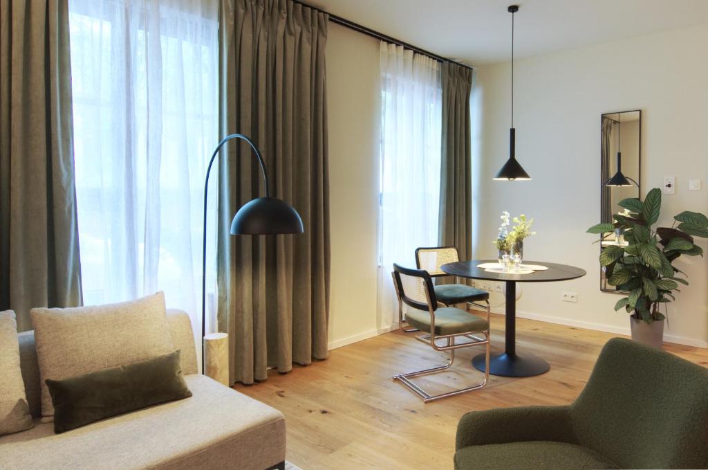 un soggiorno con tavolo e sedie di VB Boutique Apartment - Studio in belebtem Viertel nah zur Messe a Francoforte sul Meno