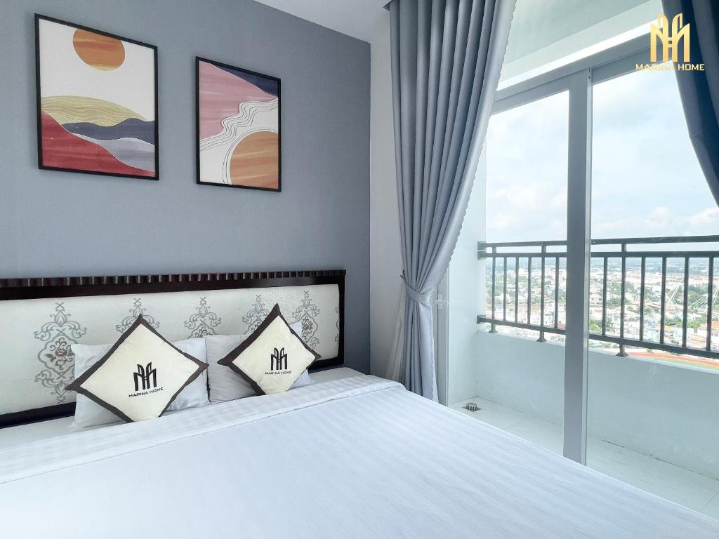 a bedroom with a bed and a large window at Căn hộ Khách sạn cao cấp Marina Plaza Long Xuyên in Ấp Ðông An (1)