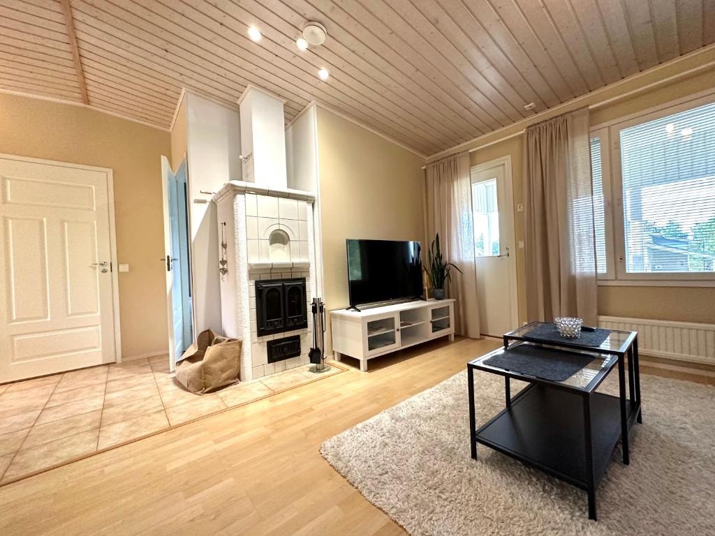 a large living room with a television and a table at Lumikukka Vuokatti in Kajaani