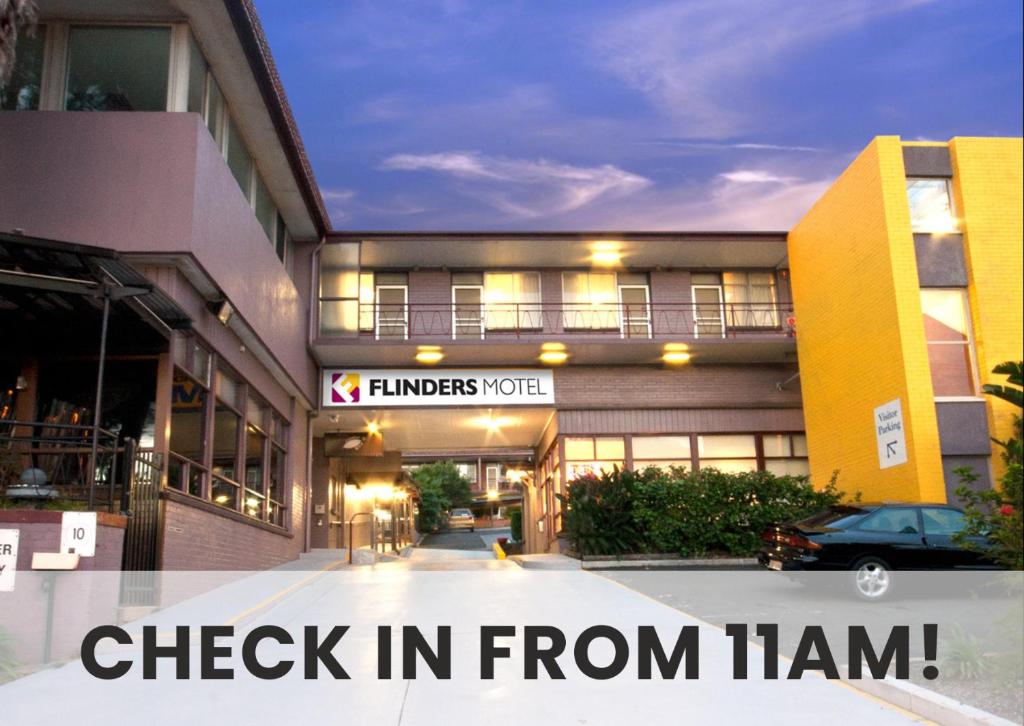 un edificio con un cartel que lee el check in de Titán en Flinders Motel, en Wollongong
