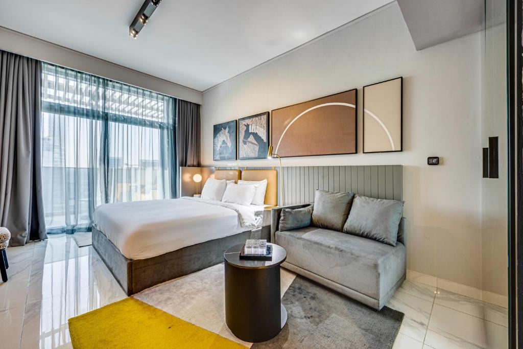 een hotelkamer met een bed en een bank bij Stylish canal view apartment in Business Bay in Dubai