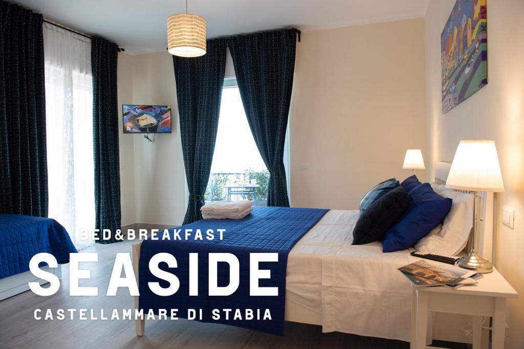 a bedroom with a bed with blue sheets and a window at B&B SEASIDE in Castellammare di Stabia
