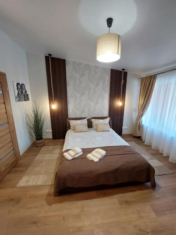 a bedroom with a large bed with two towels on it at Lapių Ola in Utena