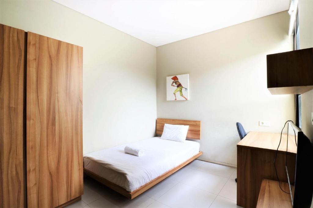 a small bedroom with a bed and a desk at M Pavilion - BSD in Serpong