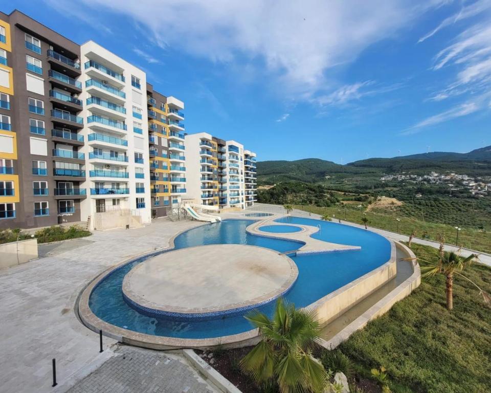 a large swimming pool in front of a building at App. Meeres Blick Eşin Golf Resort in Soke