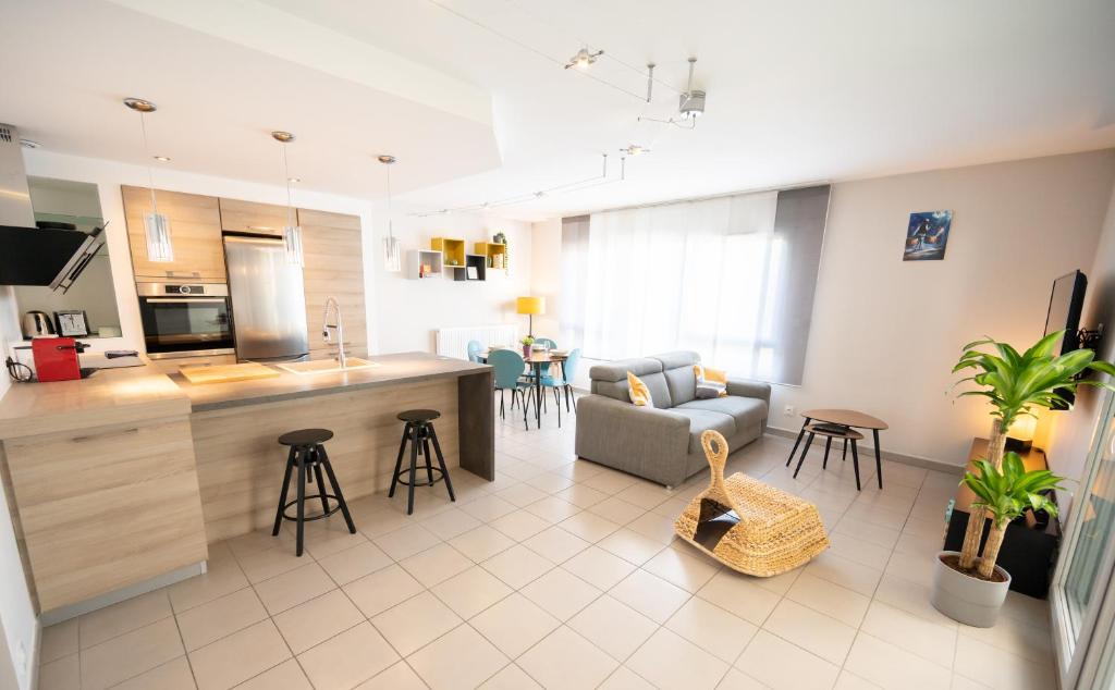 une cuisine et un salon avec un canapé et une table dans l'établissement Chez Léon - Métro, Bus, Garage Double, 6 Personnes, à Villeurbanne