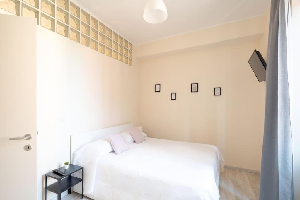 a white bedroom with a white bed and a window at Grazioso Appartamento Trastevere in Rome