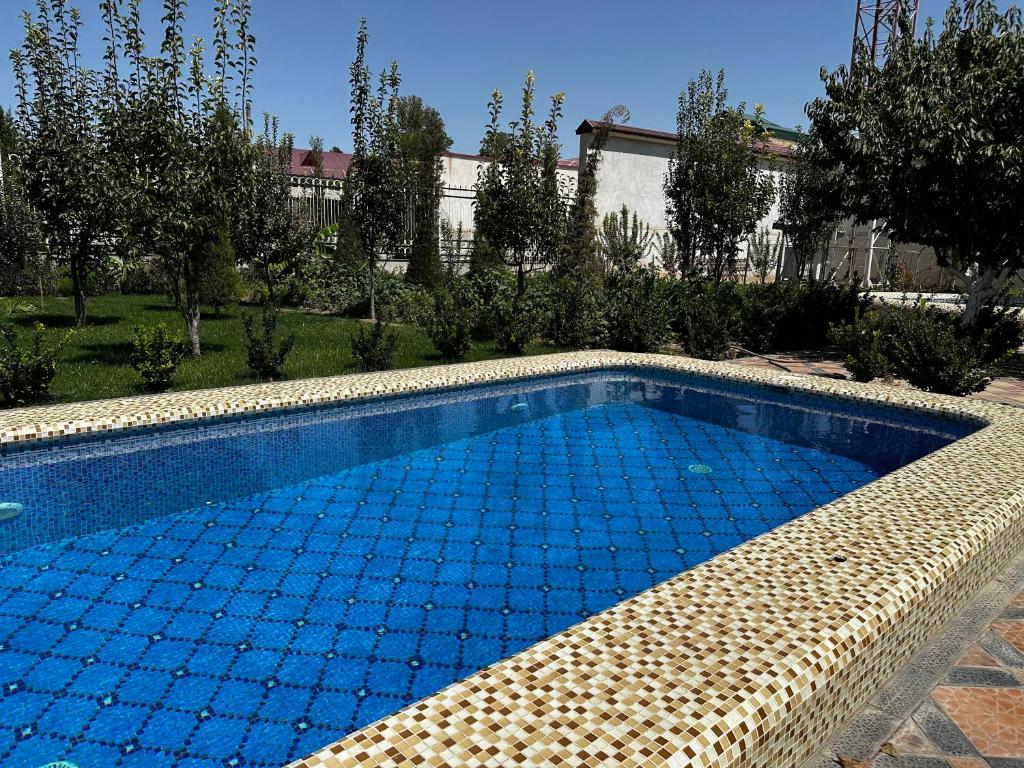 a swimming pool in a yard next to a house at Samarabonu Hotel in Samarkand