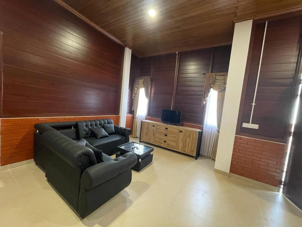 een woonkamer met een bank en een televisie bij Villa Arjuna 