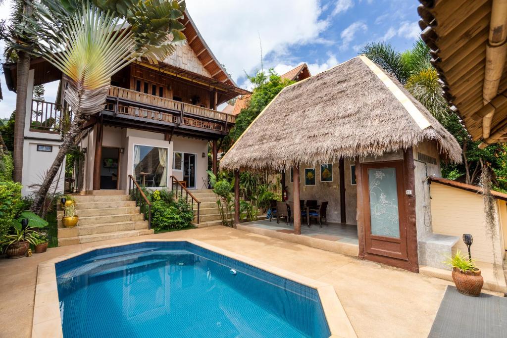 a house with a swimming pool in front of a house at Villa Ayutthaya at Kantiang Bay in Ko Lanta