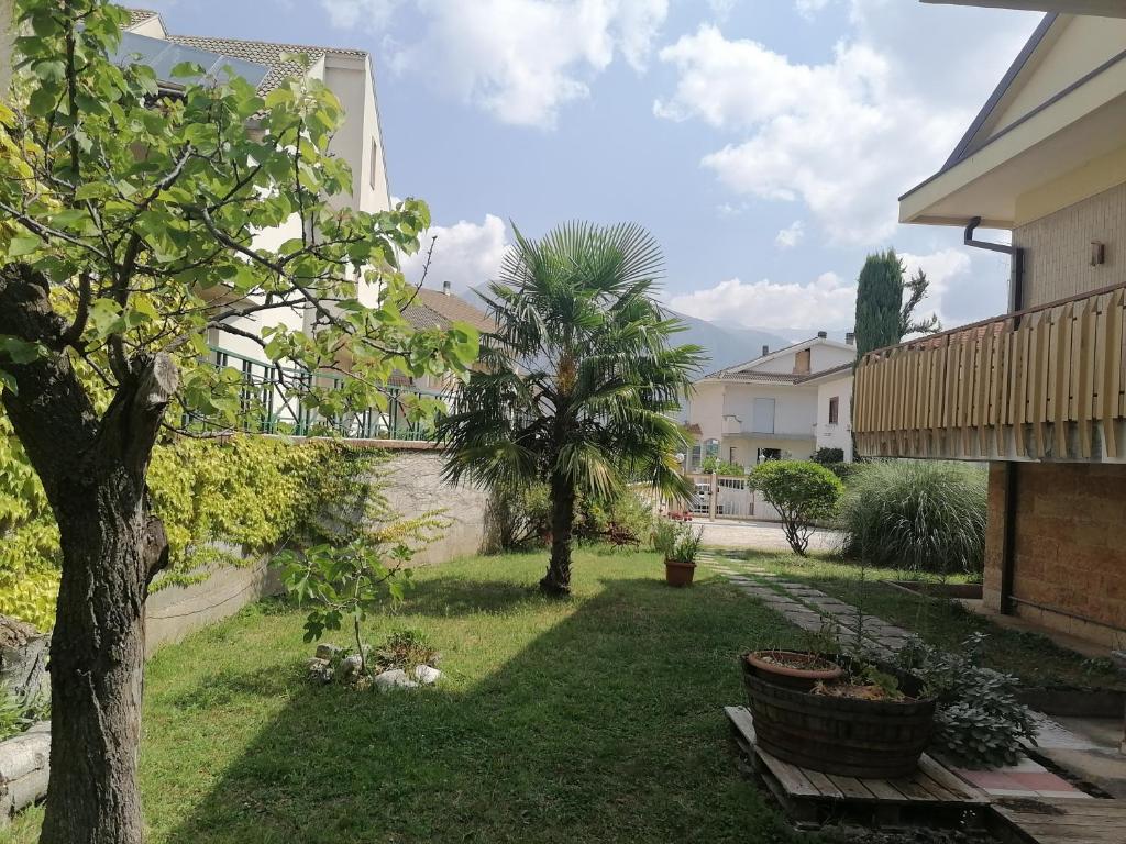 un cortile con alberi e piante in una casa di B&b Villaggio Sole a Sulmona