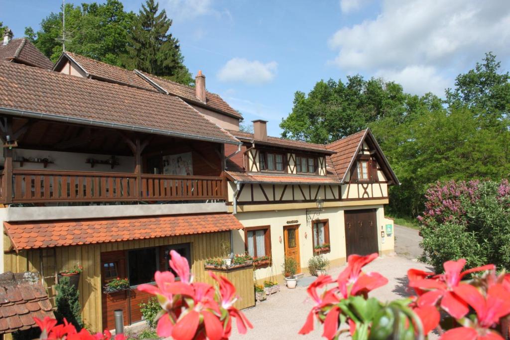 uma casa antiga com um alpendre e uma varanda em La Maison de Vacances em Nothalten