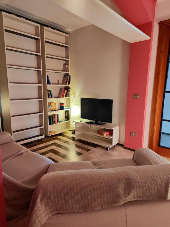 salon z kanapą i telewizorem z płaskim ekranem w obiekcie Casa vacanza "IL GIRASOLE" w mieście Noci