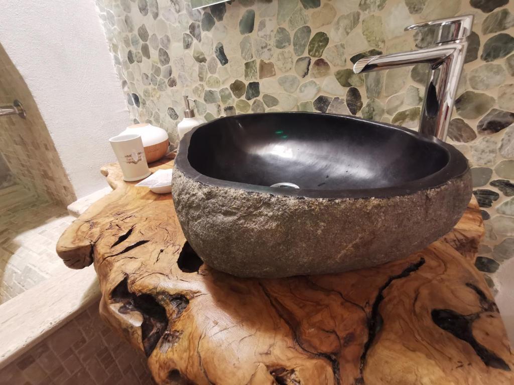 a bathroom with a sink on top of a wooden cutting board at DIONISO Bed & Wellness in Taranto