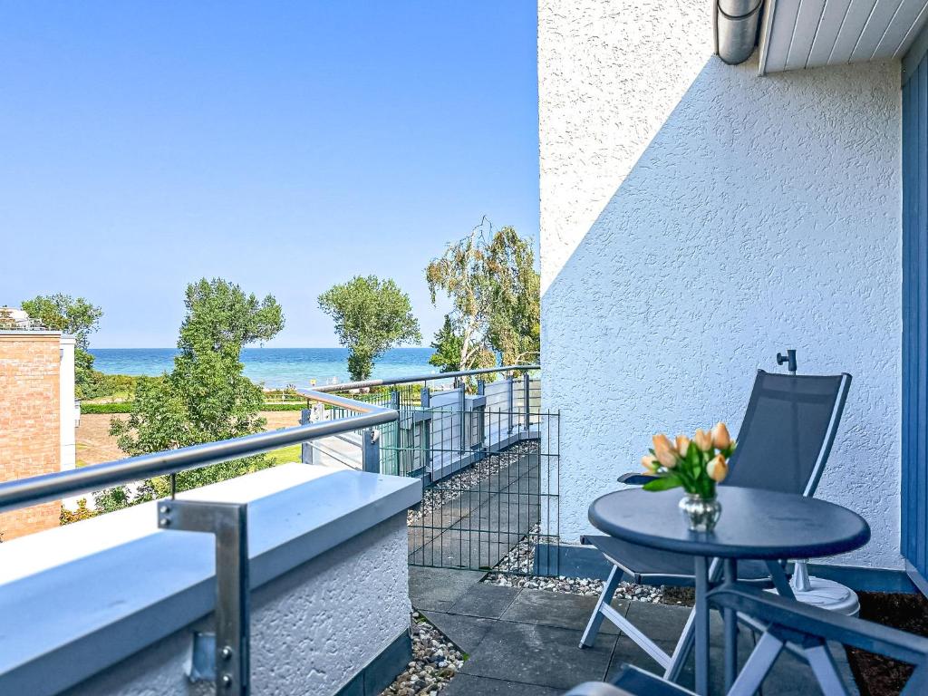 a balcony with a table and chairs and the ocean at Dünenblick Wohnung 49 in Boltenhagen
