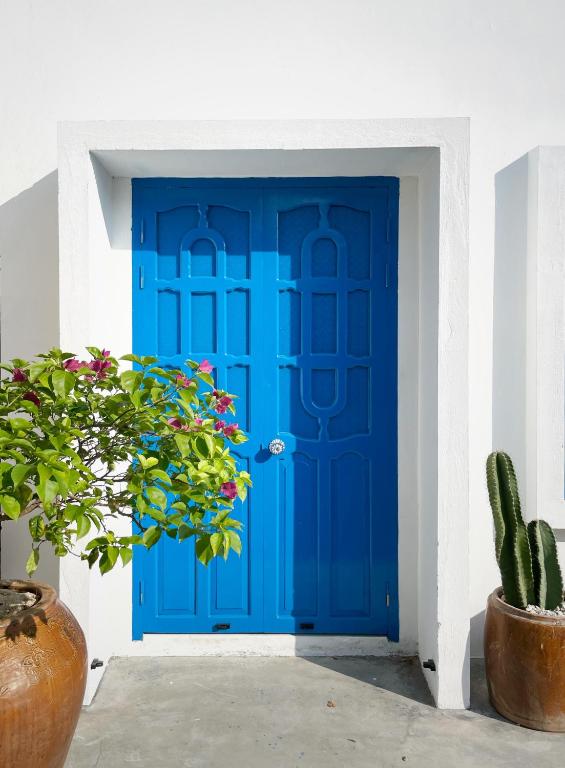a blue door in a white building with a cactus at QiHome Phú Quý in Cu Lao Thu