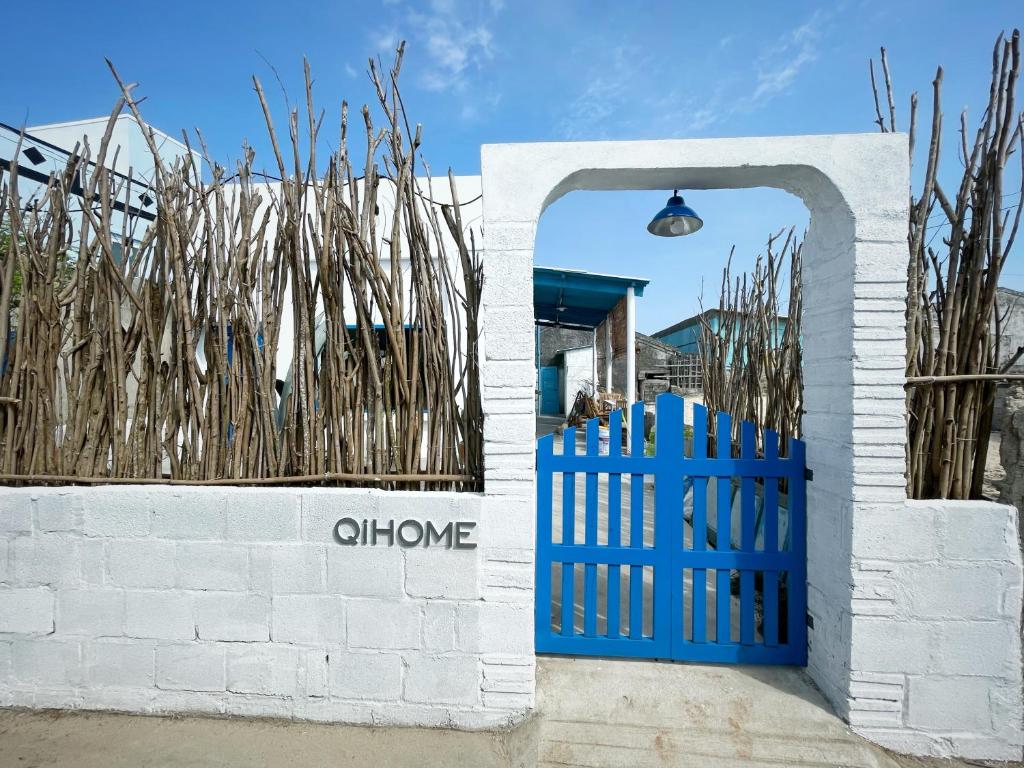 a blue gate in front of a white brick wall at QiHome Phú Quý in Cu Lao Thu