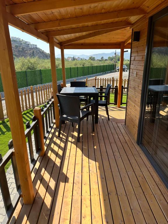 une terrasse en bois avec une table et des chaises. dans l'établissement Lake house kayacık Resort, à Dalaman