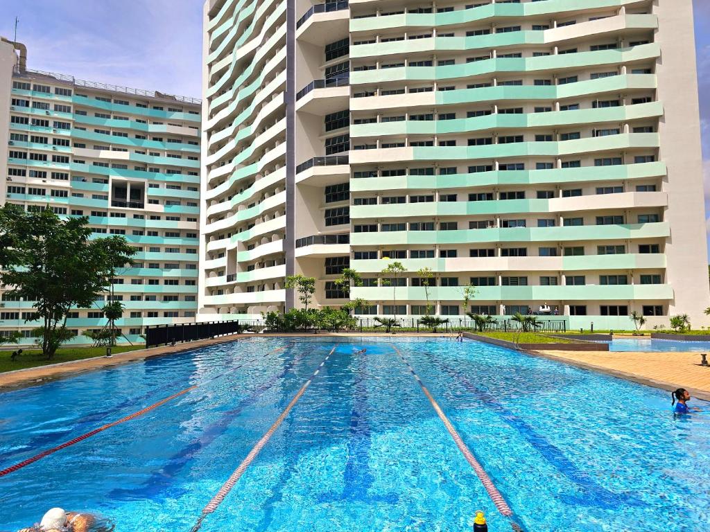 a large swimming pool in front of a building at Acellyne Suites at The Residences at Commonwealth by Century in Manila