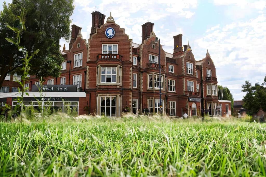 a large red brick building with a clock on it at The Orwell Hotel in Felixstowe