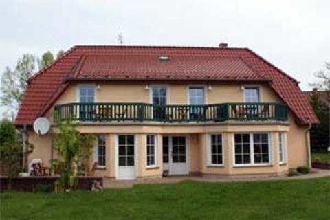 a large house with a balcony on top of it at Landsitz Rügen in Glowe