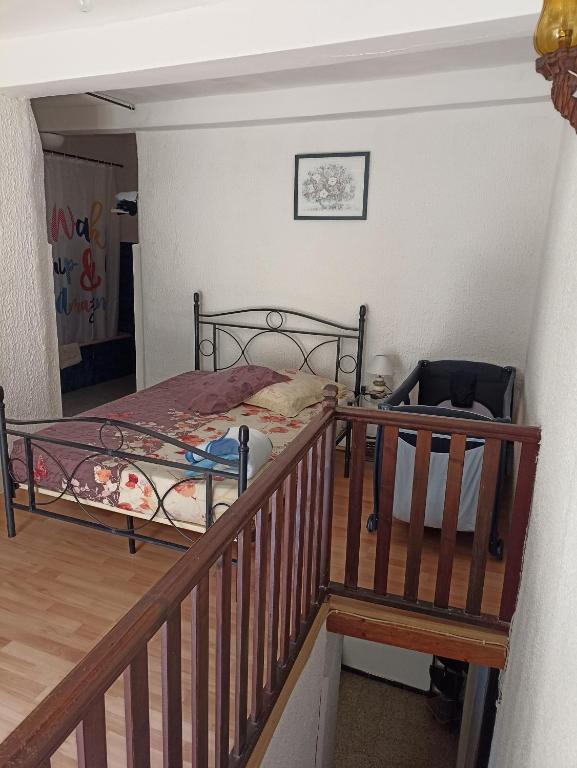 a bedroom with a bed and a stair railing at Duplex meublé Mercantour in Fontan